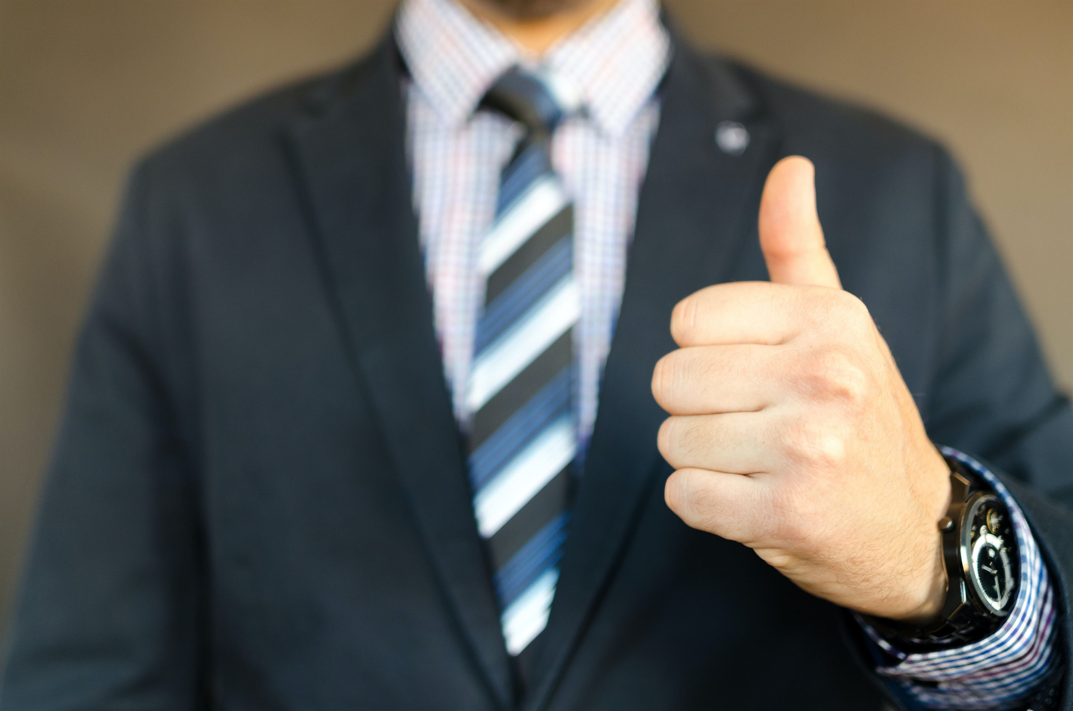 A person holding a thumb up. Title search, insurance, and escrow services.
